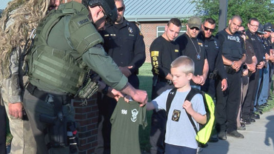Sea of blue: Boy escorted back to school by 70 police officers after dad killed in the line of duty