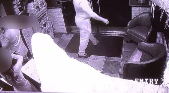 EXCLUSIVE: Surveillance video shows alleged mail bomber reading newspapers at strip club night before arrest