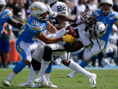 Oakland Raiders punt returner Dwayne Harris, right, is hauled down by the Los Angeles Chargers' Austin Ekeler during the first half of an NFL football game Sunday, Oct. 7, 2018, in Carson, Calif. (AP Photo/Mark J. Terrill)