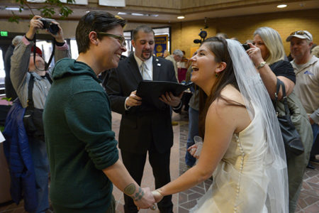 Jax Collins, left, and Heather Collins are overjoyed as they are married by Rev. Christopher Scuderi of Universal Heart Ministry on Monday (Dec. 23), at the Salt Lake City County offices. Hundreds of same-sex couples descended on county clerk offices around the state of Utah to request marriage licenses. A federal judge in Utah struck down the state's ban on same-sex marriage last Friday, saying the law violates the U.S. Constitution's guarantees of equal protection and due process. For use with RNS-STL-MARRIAGE, transmitted on December 23, 2013, Photo by Francisco Kjolseth  |  The Salt Lake Tribune