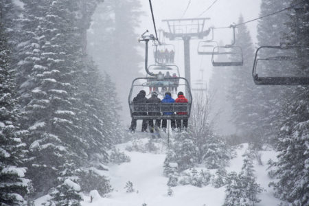 In this photo provided by Northstar California, skiers ride a chair lift as snow falls Thursday, March 1, 2018, at the Northstar California resort in Truckee, Calif. A major winter storm moved across Northern California on Thursday, bringing heavy snow and strong winds to the Sierra Nevada and steady rain through the region that disrupted the morning commute. (Northstar California via AP)