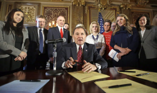 FILE - In this April 19, 2016, file photo, Utah Gov. Gary Herbert looks up during a ceremonial signing of a state resolution declaring pornography a public health crisis, at the Utah State Capitol, in Salt Lake City. More than a dozen states have moved to declare pornography a public health crisis, encouraging supporters but raising concerns among experts who say the label goes too far and carries its own risks. Arizona became the latest of 16th state to pass a resolution in at least one legislative chamber on Monday, May 6, 2019, calling for a systemic effort to prevent exposure to porn that's increasingly accessible to kids at younger ages online. (AP Photo/Rick Bowmer, File)