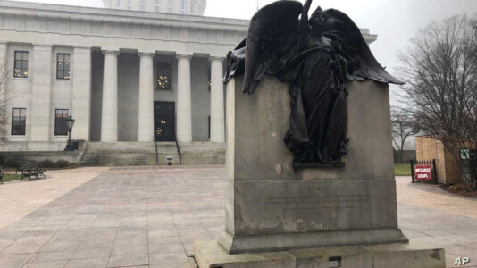 "Peace," a statue on the grounds of the Ohio Statehouse that commemorates Civil War soldiers "And The Loyal Women Of That Period," stands clear of morning fog on Wednesday, Jan. 15, 2020, in Columbus, Ohio. The Statehouse grounds don't include a statue of a real woman from Ohio history, an occurrence the Women's Suffrage Centennial Commission hopes to remedy by proposing a new memorial honoring the women who fought for the right to vote. (AP Photo/Andrew Welsh-Huggins)