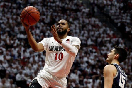 San Diego State guard KJ Feagin (10) shoots as Utah State guard Abel Porter (15) defends during the first half of an NCAA college basketball game Saturday, Feb. 1, 2020, in San Diego. (AP Photo/Gregory Bull)