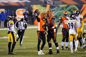 Cincinnati Bengals quarterback Ryan Finley (5) reacts with offensive guard Fred Johnson (74) after Finley rushed for a first down during the second half of an NFL football game against the Pittsburgh Steelers, Monday, Dec. 21, 2020, in Cincinnati. (AP Photo/Bryan Woolston)