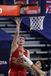 Dixie State forward Hunter Schofield, left, shoots over Gonzaga guard Andrew Nembhard during the first half of an NCAA college basketball game in Spokane, Wash., Tuesday, Dec. 29, 2020. (AP Photo/Young Kwak)