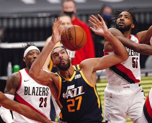 Portland Trail Blazers forward Derrick Jones Jr., right, and Utah Jazz center Rudy Gobert, middle, vie for a rebound as Trail Blazers forward Robert Covington, left, watches during the first half of an NBA basketball game in Portland, Ore., Wednesday, Dec. 23, 2020. (AP Photo/Steve Dipaola)
