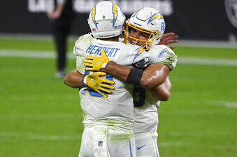 Los Angeles Chargers tight end Hunter Henry, right, embraces quarterback Justin Herbert (10) after defeating the Las Vegas Raiders in overtime of an NFL football game, Thursday, Dec. 17, 2020, in Las Vegas. (AP Photo/David Becker)
