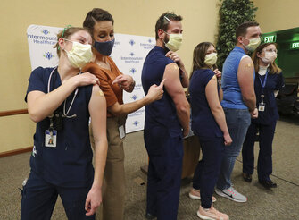 Registered nurse Sophie Woodbury, left, poses for a photo with state epidemiologist Dr. Angela Dunn, and fellow registered nurses Monte Roberts, Amanda Vicchrilli, William Brunt and Julie Nelson at LDS Hospital in Salt Lake city on on Tuesday, Dec. 15, 2020. Woodbury, Roberts, Vicchrilli and Burnt were vaccinated for the coronavirus by Nelson. (Jeffrey D. Allred/The Deseret News via AP)