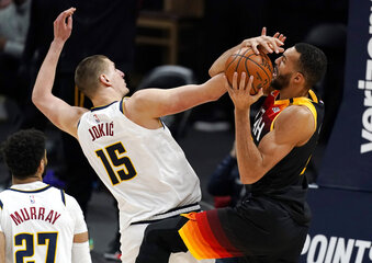 Utah Jazz center Rudy Gobert, right, fights for control of a rebound with Denver Nuggets center Nikola Jokic in the second half of an NBA basketball game Sunday, Jan. 31, 2021, in Denver. (AP Photo/David Zalubowski)