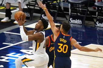 Utah Jazz guard Donovan Mitchell (45) goes to the basket as Golden State Warriors guard Stephen Curry (30) defends during the first half of an NBA basketball game Saturday, Jan. 23, 2021, in Salt Lake City. (AP Photo/Rick Bowmer)