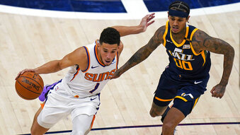 Phoenix Suns guard Devin Booker (1) drives around Utah Jazz guard Jordan Clarkson (00) during the second half of an NBA basketball game Thursday, Dec. 31, 2020, in Salt Lake City. (AP Photo/Rick Bowmer)