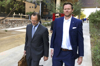 FILE - In this Nov. 5, 2019, file photo,  former Maricopa County Assessor Paul Petersen, right, walks with his attorney, Kurt Altman, as they leave a court hearing in Phoenix. Petersen, who has acknowledged running an adoption scheme in three states that involved women from the Marshall Islands, is required to report to federal prison by midday Thursday, Jan. 21, 2021, to start serving a 6-year sentence for his guilty plea in Arkansas to conspiring to commit human smuggling. Petersen also is awaiting sentencing for related convictions in Arizona and in Utah. (AP Photo/Jacques Billeaud, File)