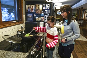 CORRECTS TO MISSY MILLARD-Missy Millard, left, cooks with her mom, Kim, in their home in Layton on Thursday, Jan. 28, 2021. (Annie Barker/The Deseret News via AP)
