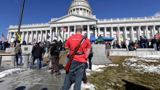 FILE - A man carries his weapon during a second amendment gun rally at Utah State Capitol on Feb. 8, 2020, in Salt Lake City. Utah is one of several more states weighing proposals this year that would allow people to carry concealed guns without having to get a permit, a trend supporters say bolsters Second Amendment rights but is alarming to gun-control advocates. (AP Photo/Rick Bowmer, File)