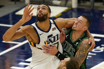 Utah Jazz center Rudy Gobert, left, and Boston Celtics center Daniel Theis, right, battle for position under the boards in the second half during an NBA basketball game Tuesday, Feb. 9, 2021, in Salt Lake City. (AP Photo/Rick Bowmer)