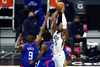 Utah Jazz guard Donovan Mitchell, right, shoots over Los Angeles Clippers' Patrick Beverley, center, and Serge Ibaka (9) during the first half of an NBA basketball game Wednesday, Feb. 17, 2021, in Los Angeles. (AP Photo/Marcio Jose Sanchez)