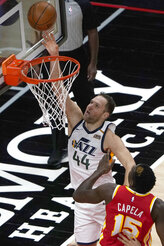 Utah Jazz forward Bojan Bogdanovic (44) goes up for a basket as Atlanta Hawks center Clint Capela (15) defends in the first half of an NBA basketball game Thursday, Feb. 4, 2021, in Atlanta. (AP Photo/John Bazemore)