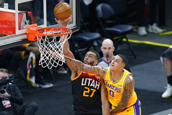 Utah Jazz center Rudy Gobert (27) scores against Los Angeles Lakers forward Kyle Kuzma (0) during the first half of an NBA basketball game Wednesday, Feb. 24, 2021, in Salt Lake City. (AP Photo/Rick Bowmer)