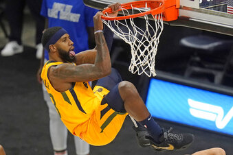 Utah Jazz forward Royce O'Neale hangs from the rim after dunking against the Detroit Pistons during the second half of an NBA basketball game Tuesday, Feb. 2, 2021, in Salt Lake City. (AP Photo/Rick Bowmer)