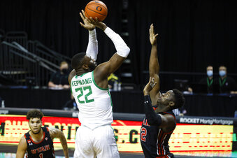 Oregon center Franck Kepnang (22) shoots over Utah center Lahat Thioune (32) during an NCAA college basketball game in Eugene, Ore., Saturday, Feb. 20, 2021. (AP Photo/Thomas Boyd)