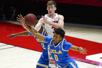 Utah center Branden Carlson, top rear, and UCLA guard Jaylen Clark (0) vie for the ball during the first half of an NCAA college basketball game Thursday, Feb. 25, 2021, in Salt Lake City. (AP Photo/Rick Bowmer)