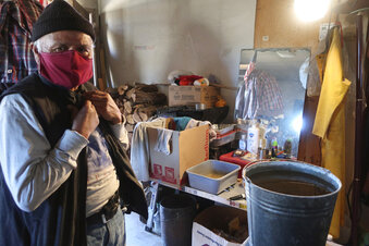 Raymond Clark stands in front of his makeshift washing station in his home in Teesto, Arizona, on the Navajo Nation on Thursday, Feb. 11, 2021. Teesto workers, health representatives, volunteers and neighbors keep close tabs on another to ensure the most vulnerable citizens get the help they need. (AP Photo/Felicia Fonseca)