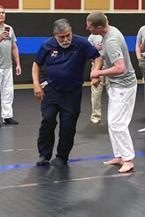Michael Johnson of the Billings, Montana Police Department grabs hold of instructor Mike Verdugo's arm while Harley Cagle of the Billings, Montana Police Department, left, captures the action on his cell phone during a training workshop on March 9, 2021, in Douglas, Wyoming. USA Judo officials spearheaded the training session to try to give officers techniques that could help them avoid using deadly force when they encounter potential suspects. (AP Photo/Eddie Pells)