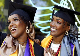 Sisters Asma Dahir, left, and Anisa Dahir take photos before their graduation ceremony at Westminster College in Salt Lake City, Utah on Friday, May 7, 2021. The graduation of the twin sisters from a refugee family marked a key milestone in a journey that is a testament to their hard work, their parents’ insistence that they place a high value on educational opportunities, and the collective efforts of those who helped two little girls who spoke only Somali when they started kindergarten. (Laura Seitz/The Deseret News via AP)