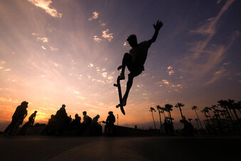 FILE - In this Wednesday, June 16, 2021, file photo, a skateboarder is silhouetted as he jumps high at the skateboard park during sunset in the Venice Beach section of Los Angeles. The Southwest U.S. continued to bake Saturday, June 19, and weather forecasters kept warnings in effect for excessive heat in Arizona, Nevada and desert areas, at least through the weekend. (AP Photo/Ringo H.W. Chiu, File)