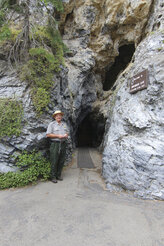 In this photo provided by the National Park Service Timpanogos Cave National Monument Ranger Jay Allen stands at the cave entrance in 2019, in American Fork, Utah. He has retired after more than 50 years guiding thousands of tourists. (National Park Service, via AP)