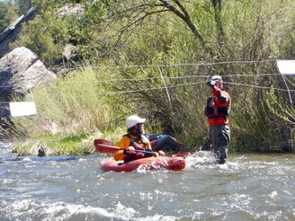 In this May 17, 2020 image provided by Sherry Barrett  boaters navigate a wire property fence across the Pecos River in northern New Mexico. A dispute over public access to streams and other waterways that flow through private property is simmering in New Mexico. (Sherry Barrett via AP)