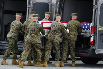 A Marine Corps carry team loads a transfer case containing the remains of Marine Corps Staff Sgt. Taylor Hoover, 31, of Salt Lake City, Utah, at Dover Air Force Base, Del. President Joe Biden embarked on a solemn journey Sunday to honor and mourn the 13 U.S. troops killed in the suicide attack near the Kabul airport as their remains return to U.S. soil from Afghanistan. (AP Photo/Manuel Balce Ceneta)