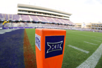 FILE - In this Saturday, Sept. 4, 2021, file photo, a Big 12 Conference logo is displayed on a goal line pylon before Duquesne played TCU in an NCAA college football game, in Fort Worth, Texas. The Big 12 has extended membership invitations to BYU, UCF, Cincinnati and Houston to join the Power Five league. That comes in advance of the league losing Oklahoma and Texas to the Southeastern Conference. (AP Photo/Ron Jenkins, File)