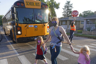 Sandra Young arrives at Whittier Elementary School with her daughters Baylin, 5, and Paytin, 2, on Tuesday, Aug. 24, 2021, in Salt Lake City. Kids in Salt Lake City are headed back to school Tuesday wearing masks after the mayor issued a mandate order despite heavy restrictions on mask mandates imposed by the GOP-dominated Legislature. (AP Photo/Rick Bowmer)