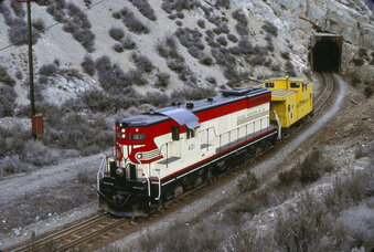 This 1978 photo provided by the Nevada Northern Railway Museum shows Locomotive 401 just east of the main tunnel on the Nevada Northern Railway west of Ely, Nev. It was the first special duty model General Motors built in 1952 in its Electro-Motive Division. It was the only one painted in the "Desert War Bonnet" scheme, a cream, scarlet and black design that remains on the train today. It's scheduled to be returned next month to the Nevada Northern Railway Museum in Ely where it was located for three decades. (Nevada Northern Railway Museum via AP)