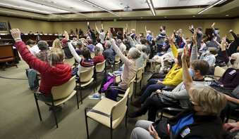 People raise their hands to signify they agree with what speakers are saying during a Legislative Redistricting Committee meeting at the Capitol in Salt Lake City on Monday, Nov. 8, 2021. (Scott G Winterton/The Deseret News via AP)