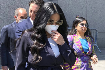 Jennifer Shah, center, of "The Real Housewives of Salt Lake City" reality television series, touches her face mask as she leaves Manhattan federal court, after pleading guilty to wire fraud conspiracy, in New York, Monday July 11, 2022. She admitted that she and others defrauded thousands of individuals nationwide for almost a decade with a telemarketing fraud that convinced victims they could make a lot of money through their own online businesses. (AP Photo/Lawrence Neumeister)