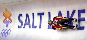 FILE - In this Feb. 9, 2002 ,file photo, Georg Hackl, of Germany, speeds past an Olympic logo during a practice run for the men's singles luge at the 2002 Salt Lake City Winter Olympics in Park City, Utah. Among the three cities that have put forth serious proposals to host the Winter Games in 2030 and 2023, only Salt Lake City's bid appears ready. (AP Photo/Elise Amendola, File)