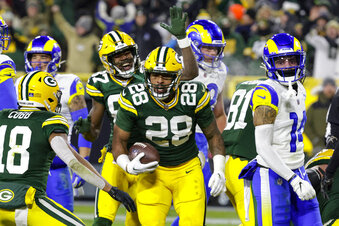 Green Bay Packers running back AJ Dillon (28) celebrates a touchdown against the Los angles Rams in the first half of an NFL football game in Green Bay, Wis. Monday, Dec. 19, 2022. (AP Photo/Mike Roemer)