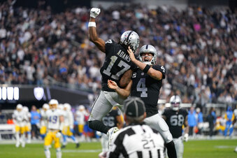 Las Vegas Raiders quarterback Derek Carr (4) and wide receiver Davante Adams (17) celebrate their touchdown during the second half of an NFL football game against the Los Angeles Chargers, Sunday, Dec. 4, 2022, in Las Vegas. (AP Photo/Matt York)