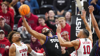TCU center Eddie Lampkin Jr. (4) pulls down a rebound between Utah's Wilguens Exacte Jr. (11) and Marco Anthony (10) during the first half of an NCAA college basketball game Wednesday, Dec. 21, 2022, in Salt Lake City. (AP Photo/Rick Bowmer)