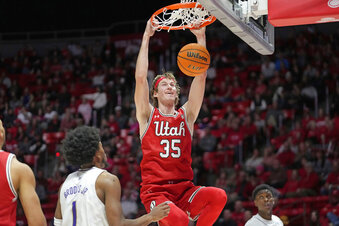 Utah center Branden Carlson (35) dunks against Washington forward Keion Brooks (1) during the second half of an NCAA college basketball game Saturday, Jan. 21, 2023, in Salt Lake City. (AP Photo/Rick Bowmer)