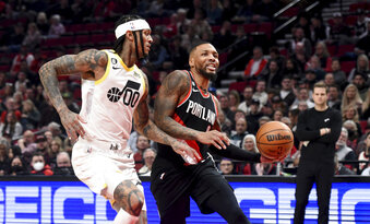 Portland Trail Blazers guard Damian Lillard, right, drives to the basket on Utah Jazz guard Jordan Clarkson, left, during the first half of an NBA basketball game in Portland, Ore., Wednesday, Jan. 25, 2023. (AP Photo/Steve Dykes)