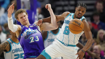 Utah Jazz forward Lauri Markkanen (23) and Charlotte Hornets guard Dennis Smith Jr. (8) battle for the ball during the second half of an NBA basketball game Monday, Jan. 23, 2023, in Salt Lake City. (AP Photo/Rick Bowmer)