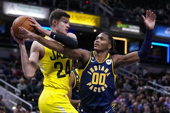 Indiana Pacers guard Bennedict Mathurin (00) fouls Utah Jazz center Walker Kessler (24) during the first half of an NBA basketball game in Indianapolis, Monday, Feb. 13, 2023. (AP Photo/Michael Conroy)