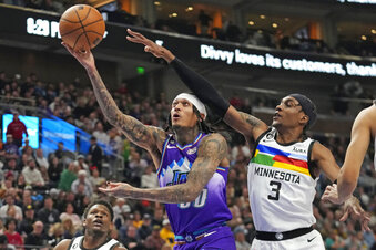 Utah Jazz guard Jordan Clarkson (00) goes to the basket as Minnesota Timberwolves forward Jaden McDaniels (3) defends during the second half of an NBA basketball game Wednesday, Feb. 8, 2023, in Salt Lake City. (AP Photo/Rick Bowmer)