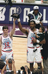 FILE - Utah Jazz teammates and co-Most Valuable Player winners John Stockton, left, and Karl Malone hold up the All-Star MVP trophy after playing for the West team, which won the 43rd NBA All-Star game 135-130 in Salt Lake City, on Feb. 21, 1993. Malone holds his daughter, Kaydee. Salt Lake City's hosting of this weekend's NBA All-Star game for the first time in three decades gives Utah another opportunity to reshape a long-held belief that the state is odd or peculiar — a years-long push that Jazz owner Ryan Smith and many other influential state leaders have prioritized.  (AP Photo/Roberto Borea, File)