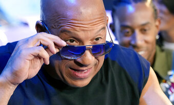 Vin Diesel, a cast member in the upcoming film "Fast X," peers over his sunglasses at photographers at the trailer launch for the film, Thursday, Feb. 9, 2023, at L.A. Live in Los Angeles. (AP Photo/Chris Pizzello)