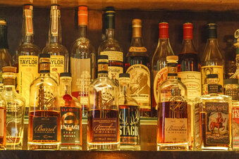 A collection of bottles of Pappy Van Winkle bourbons are seen on the top shelf right, among other fine whiskies at the "Far Bar," located in the historic Far East Building in the heart of Little Tokyo in Los Angeles on Saturday, March 4, 2023.  Buttery, smooth, oaky. These are characteristics of the best bourbons, and a growing cult of aficionados is willing to pay an astonishing amount of money for these increasingly scarce premium spirits — and even bend or break laws. (AP Photo/Damian Dovarganes)